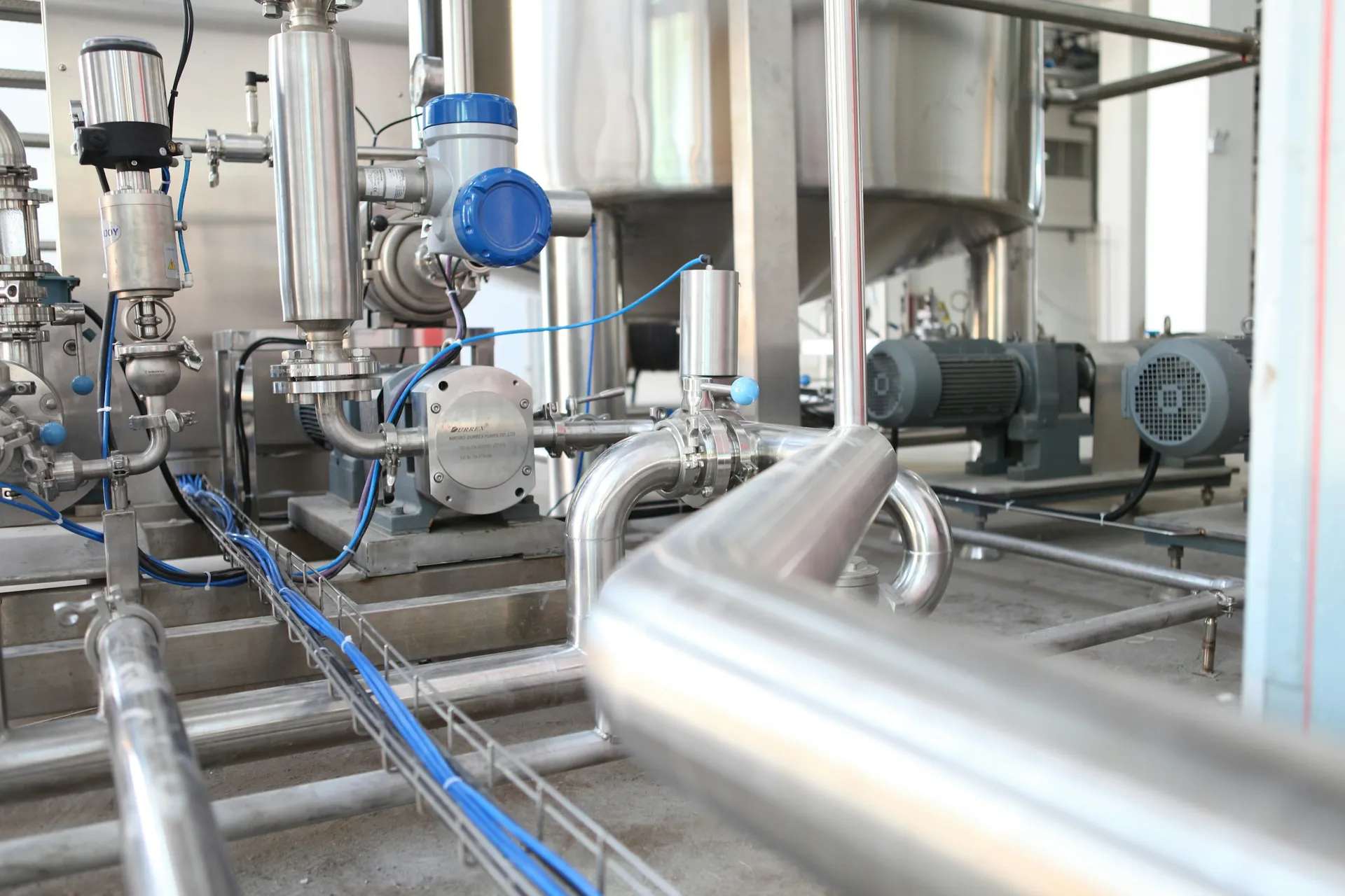 Stainless-steel process equipment with pumps and piping