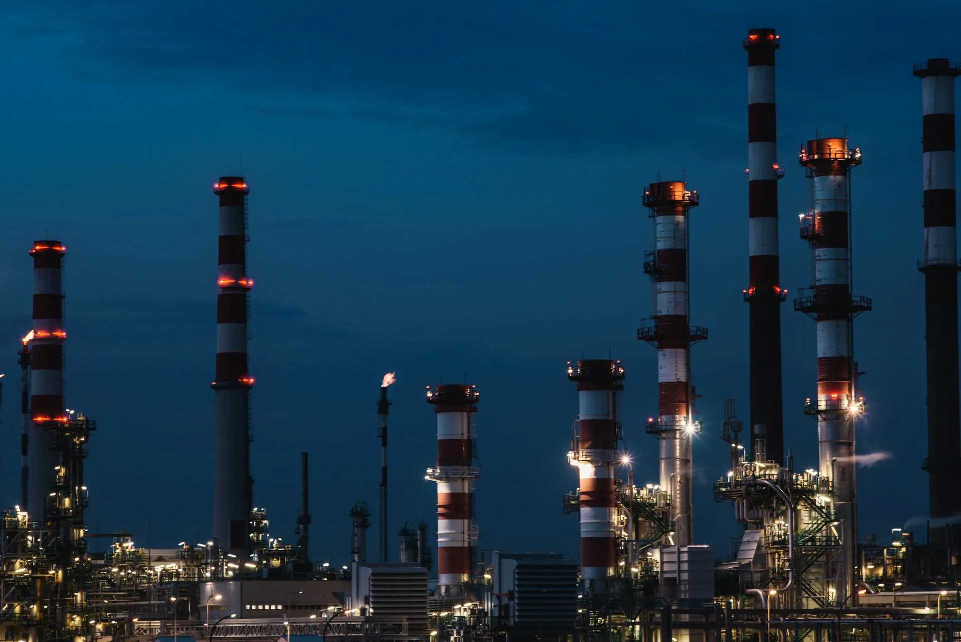 Refinery towers and flare stacks lit up at night