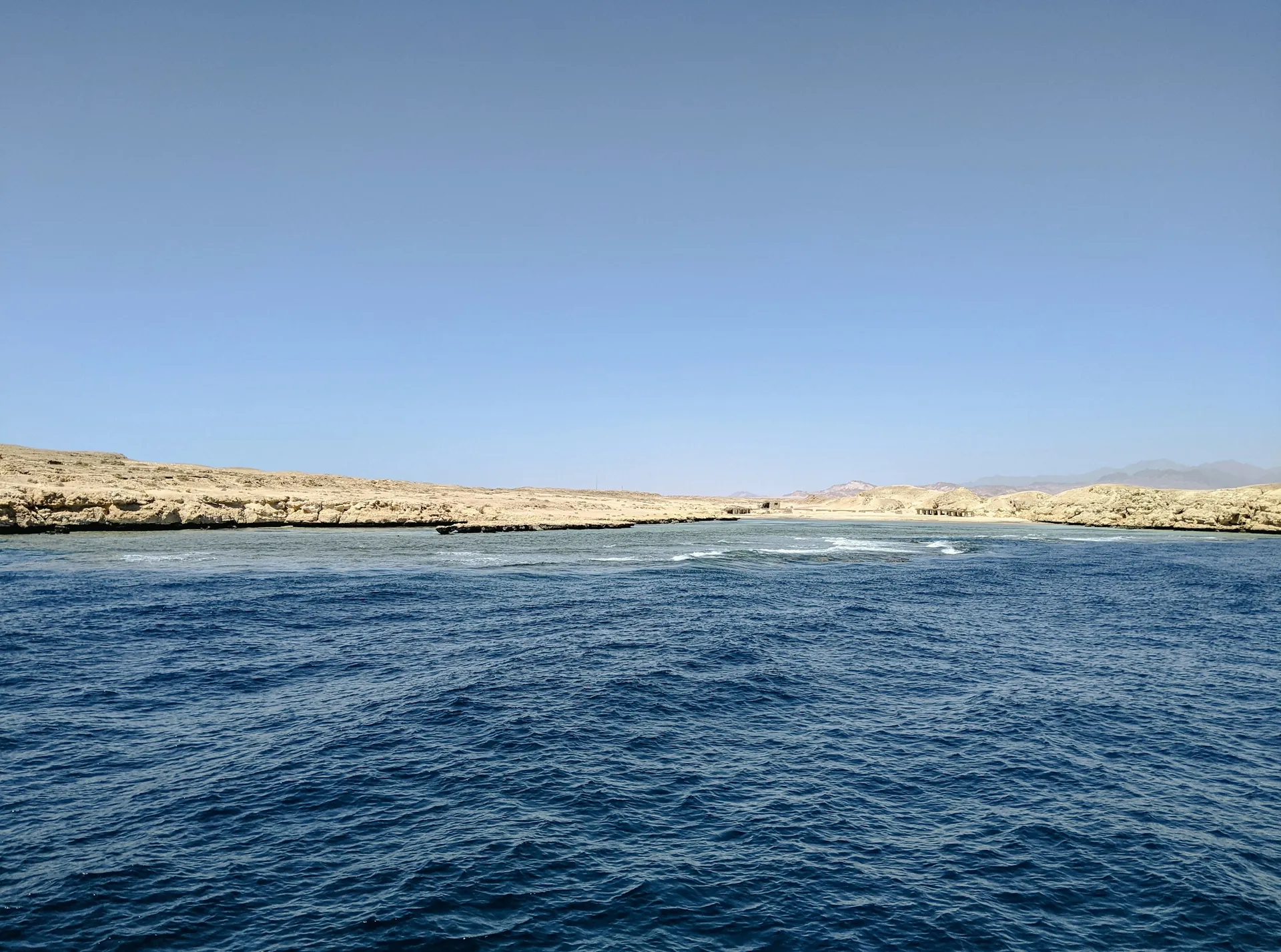 Open sea meeting a low desert coastline