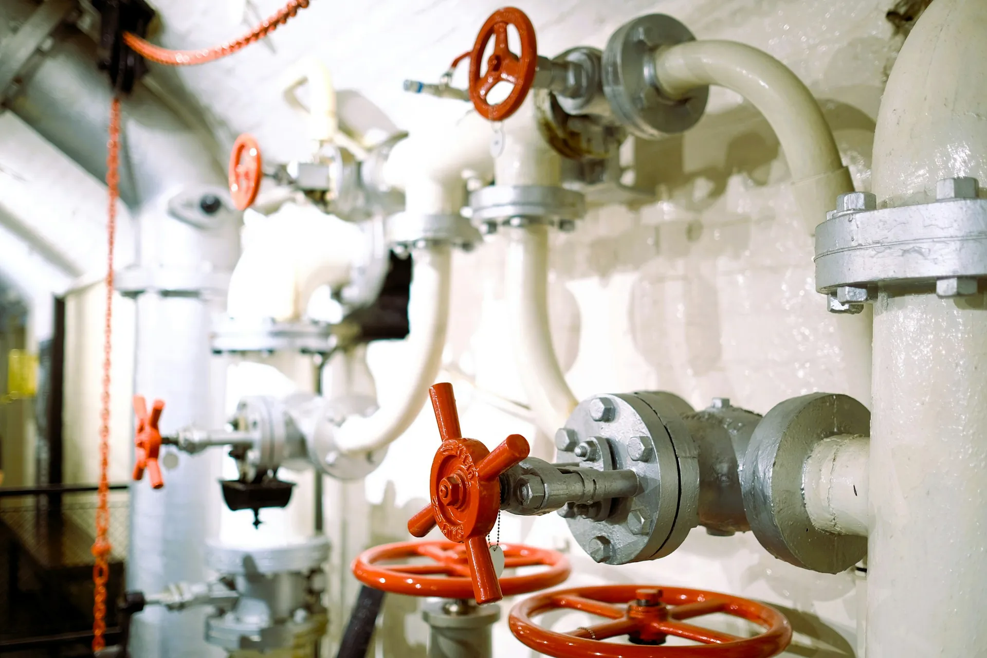 White process pipes fitted with red handwheel valves