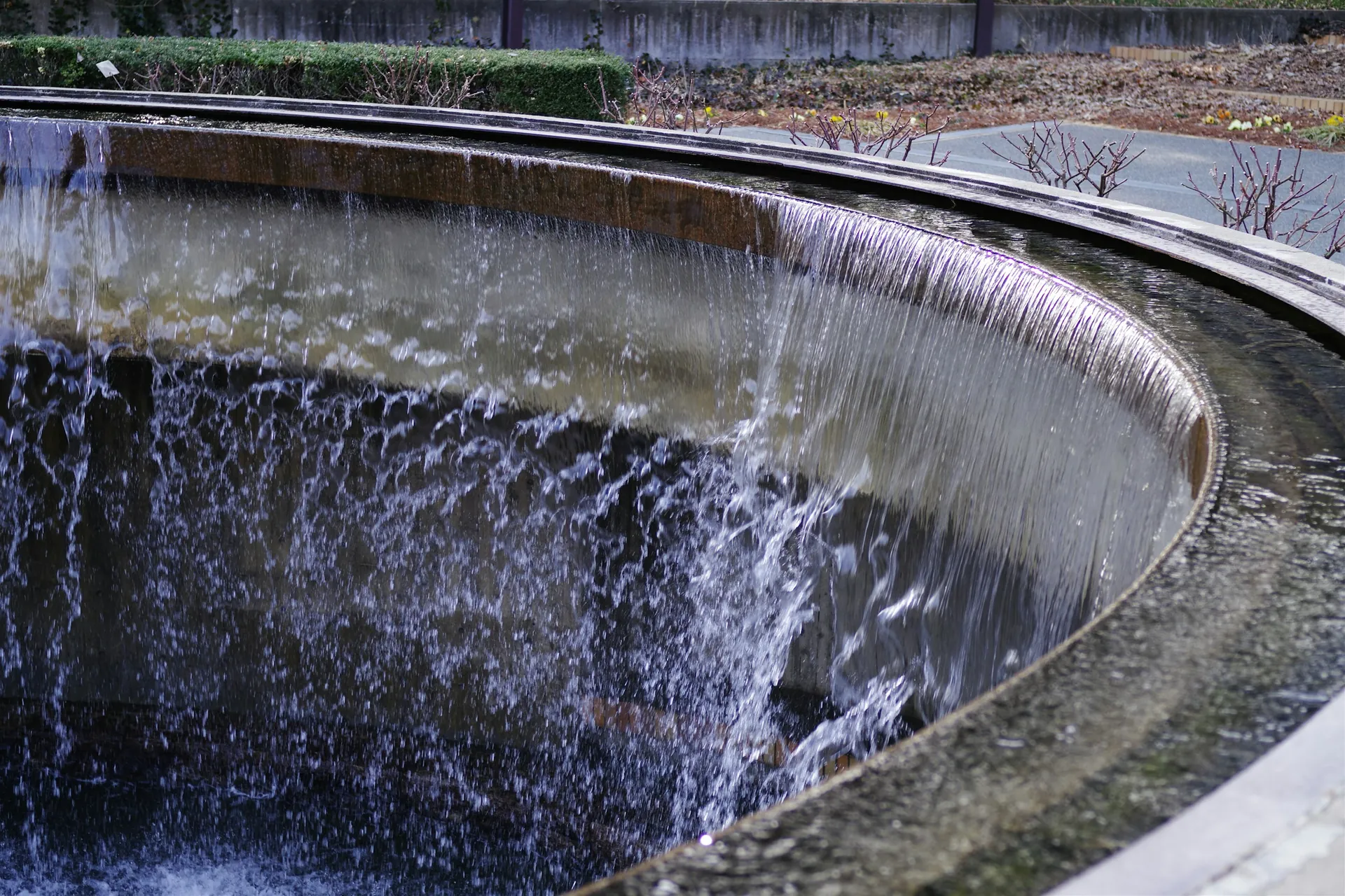 Clear water spilling over the edge of a circular basin